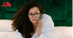 wanita sedang telepon di kasur